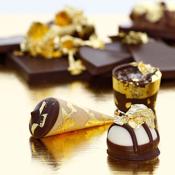 Chocolate Bar With Pieces Of Edible Gold Leaf Isolated On White